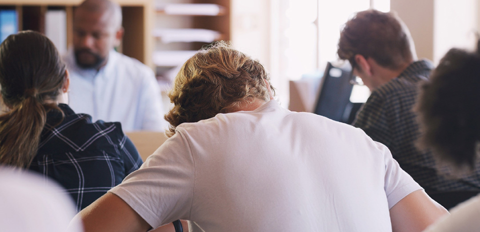 A view of students and teacher in a high school classroom, taken from the back corner.