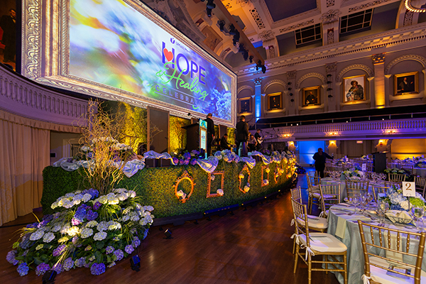 Stage with greenery, flowers and tables.