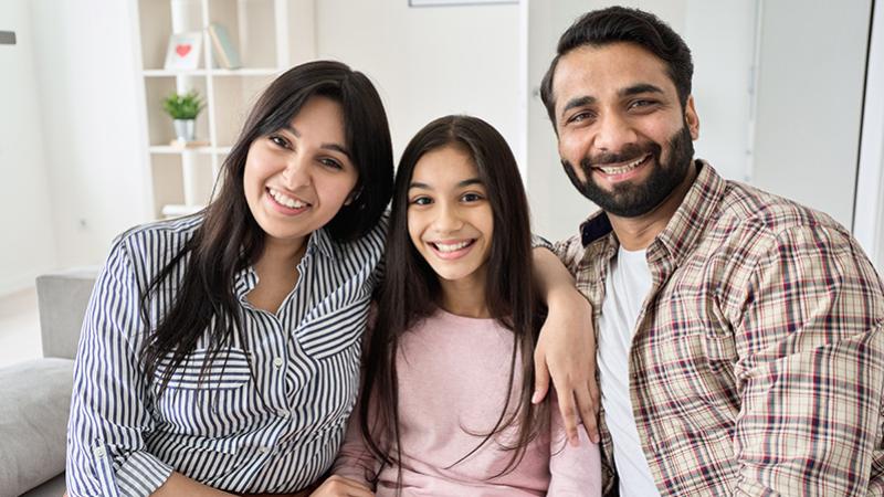 A family poses for the camera inside their home