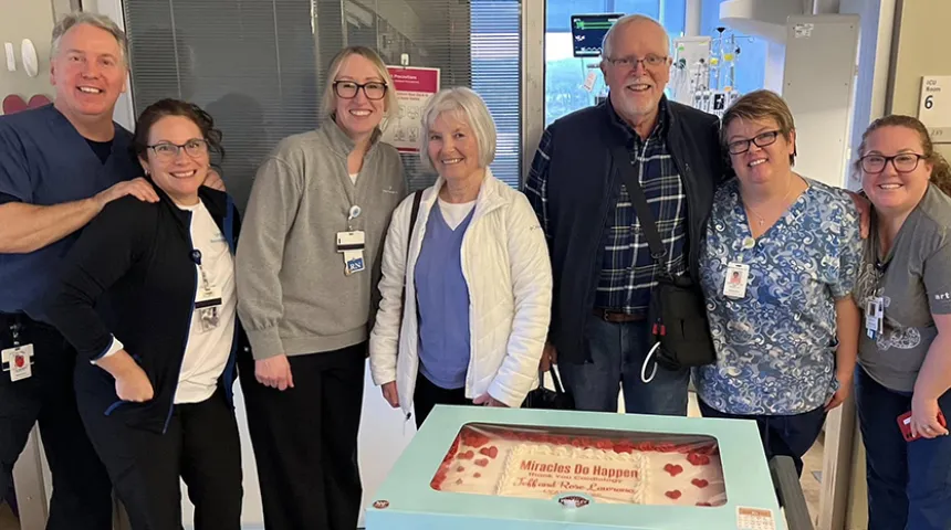 Donald "Jeff" Lawrence poses in front of the large cake he brought to visit the LVAD Program and cardiac care teams who helped him to recover after surgery.