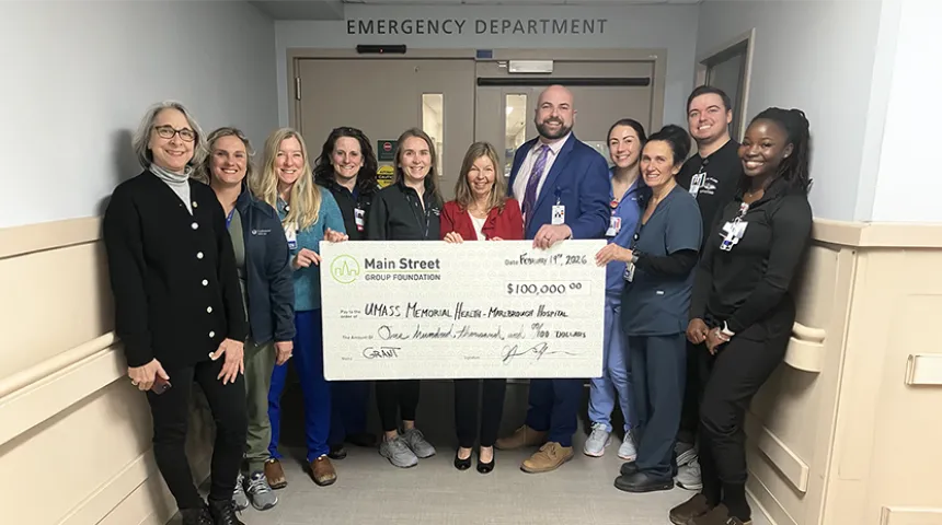 A group of caregivers at the Marlborough Campus hold up a large-size check.