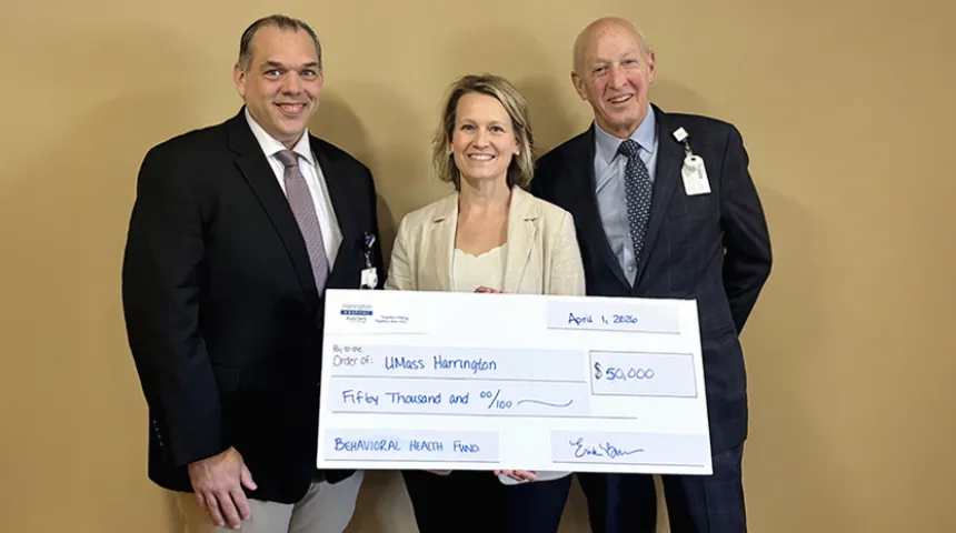 Erika Burros, representing the auxiliary, holds a large-sized donation check.  To her sides stand Harrington Board of Trustees member and the President of the Center of Hope Foundation.