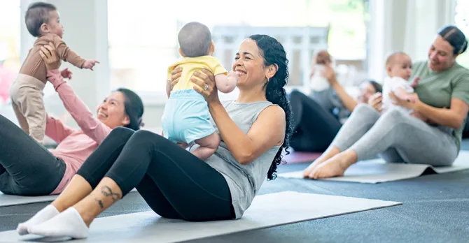 Mothers and babies participating in a fitness class together.