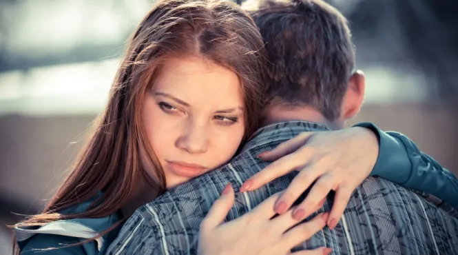 A worried teen victim of dating abuse hugs boyfriend