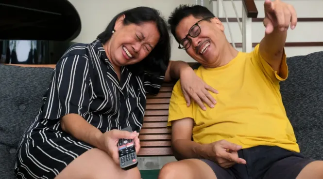 older couple watching TV and laughing which benefits heart health