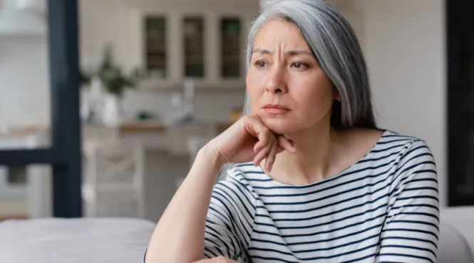A sad woman staring on a couch needing to improve her mental health