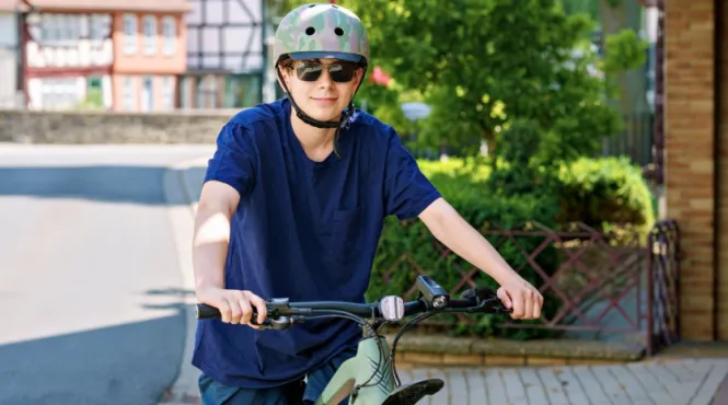 teen boy wearing proper equipment to prevent injuries while riding his bike