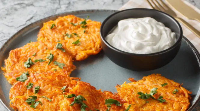 sweet potato pancakes on a plate with sour cream