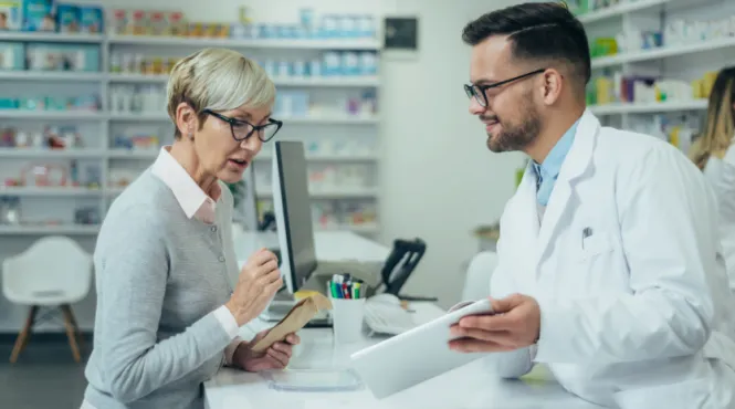 older woman talking to pharmacist about saving money on prescriptions
