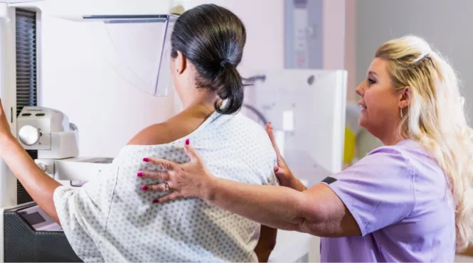 compassionate mammogram tech with a patient having a mammogram