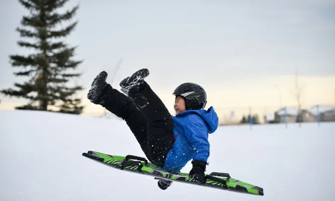 boy wearing helmet sledding following winter safety tips