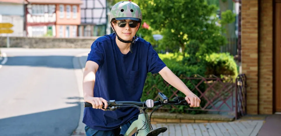 teen boy wearing proper equipment to prevent injuries while riding his bike