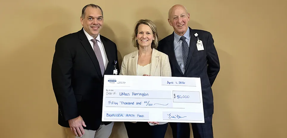 Erika Burros, representing the auxiliary, holds a large-sized donation check.  To her sides stand Harrington Board of Trustees member and the President of the Center of Hope Foundation.