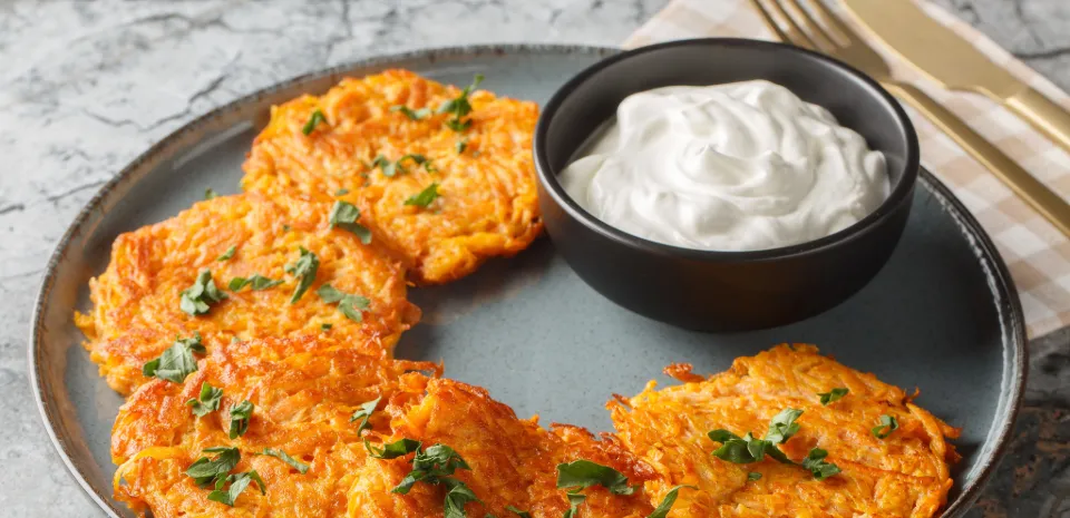 sweet potato pancakes on a plate with sour cream