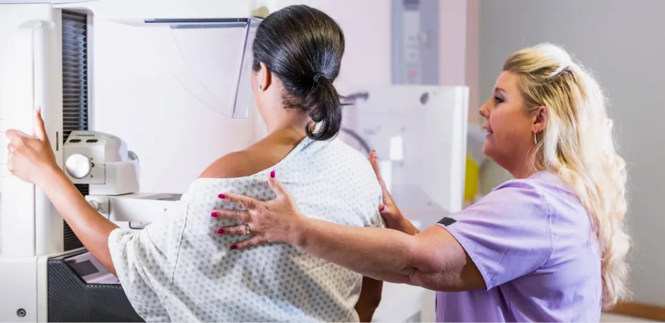 compassionate mammogram tech with a patient having a mammogram