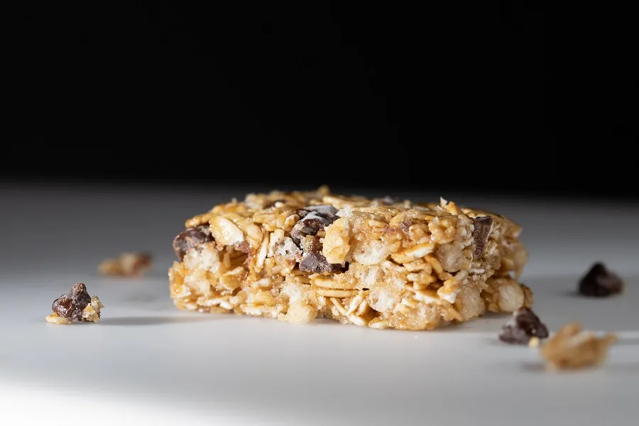 A closeup of a granola bar is shown against a black background.