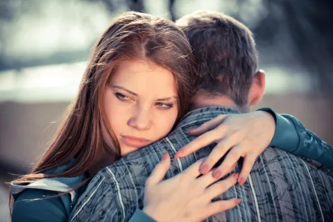 A worried teen victim of dating abuse hugs boyfriend