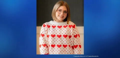 Adelaide Greenwald, looking at the camera, wearing a white sweater with a red heart pattern.