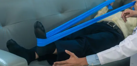 Man lying on couch doing physical therapy after same day joint replacement