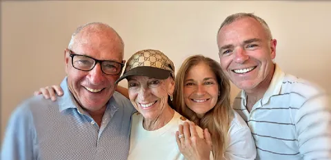 The four members of the Boucher and McManus family huddle together, smiling, for a selfie.