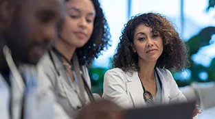 Three health care workers view a document together.