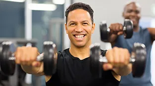 Two men doing shoulder exercises with dumbbells at the gym.