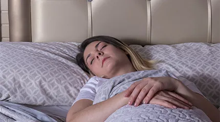 A woman sleeps on her back, with help from mindfulness.