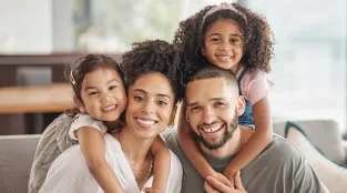 A family of four smiling at the camera.