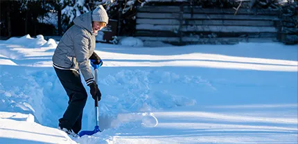 Female clearing deep snow with a shovel