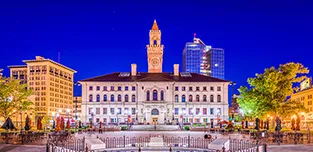 The Worcester City Hall is shown against a dark blue sky.
