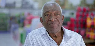 Portrait of an elderly black Brazilian man close-up face looking at camera with neutral expression with blurred background.