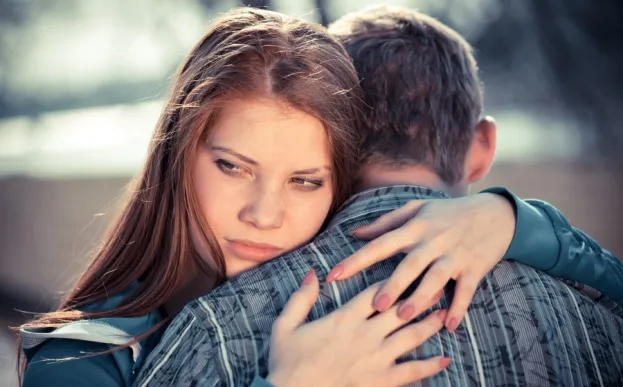 A worried teen victim of dating abuse hugs boyfriend