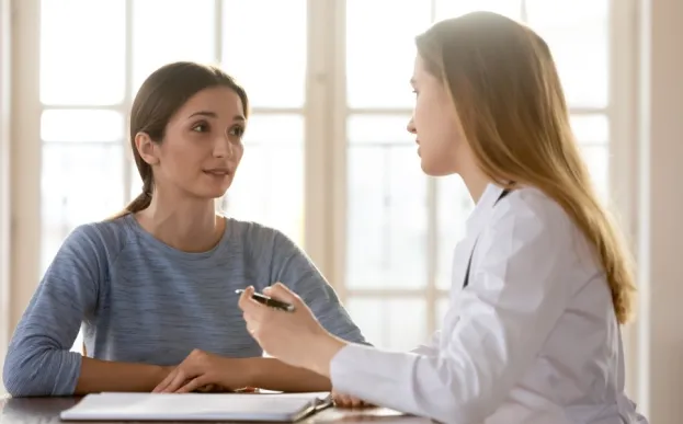 Woman with a genetic counselor at a desk talking about cancer genetic testing