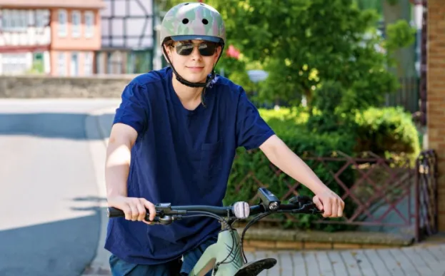 teen boy wearing proper equipment to prevent injuries while riding his bike