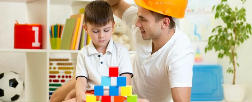 father playing blocks with his son on the floor to benefit son's mental health