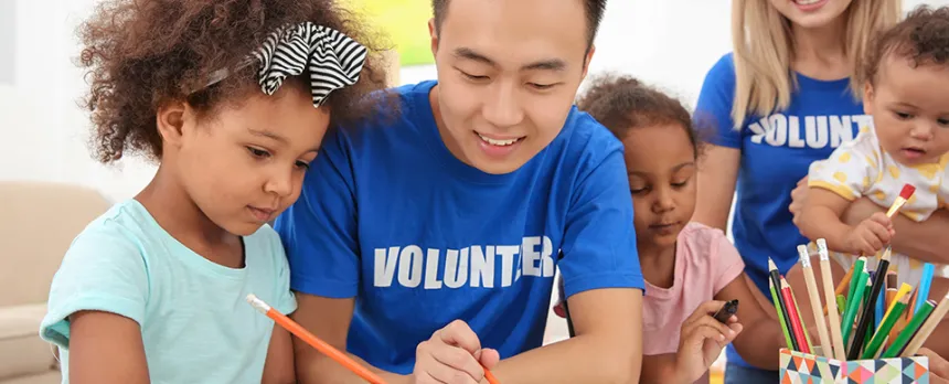 Volunteer Helping Child Draw