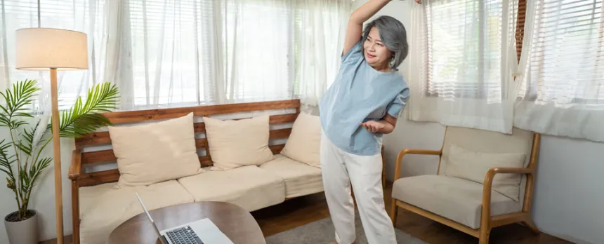 woman stretching with laptop doing at home virtual cardiac rehab