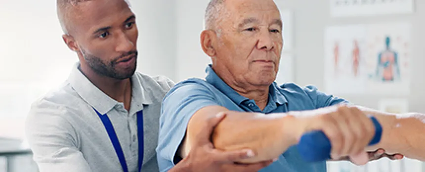 Image of man and therapist working on weights