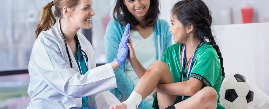A little girl high-fives the doctor in Urgent Care having had her ankle bandaged and a bad scrape treated.