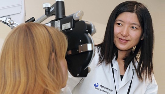 opthamologist positions machine to begin eye exam