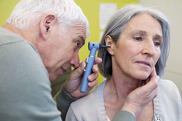 A doctor examines a patient's ear