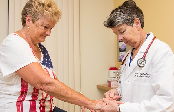 A doctor examines a patient's arthritic hands