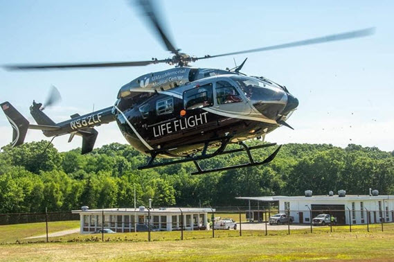 A LifeFlight helicopter is taking off at an airport.
