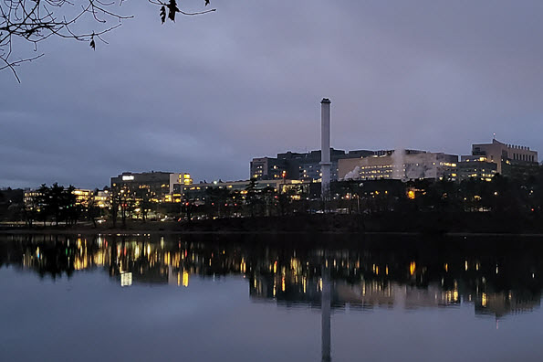 Photo of UMass Memorial Medical Center taken from the Shrewsbury side of Lake Quinsigamond at dusk.  The photo shows the Medical Center's reflection in the calm water of the lake.