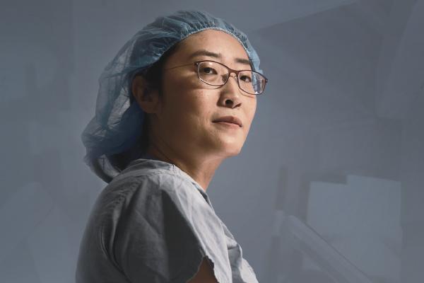 A surgeon is shown on a gray background.