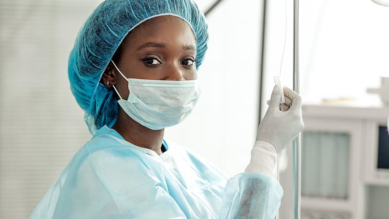 A nurse is shown earing a mask.
